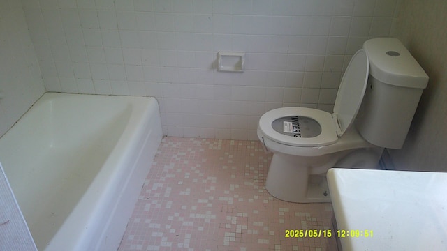 8240 Hampton Rd, Grosse Ile, MI 48138 - full bath featuring toilet, tile walls, a tub to relax in, and tile patterned floors