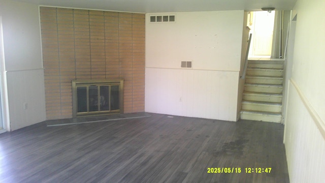 8240 Hampton Rd, Grosse Ile, MI 48138 - unfurnished living room featuring dark wood-type flooring, wainscoting, a fireplace, and stairway