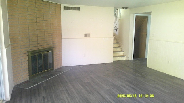 8240 Hampton Rd, Grosse Ile, MI 48138 - unfurnished living room with wood finished floors, a fireplace, stairway, and wainscoting