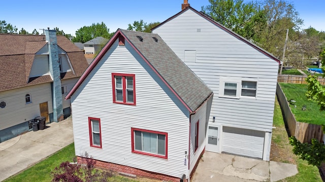 532 Chestnut St, Wyandotte, MI 48192 - rear view of property featuring an attached garage, fence, and roof with shingles