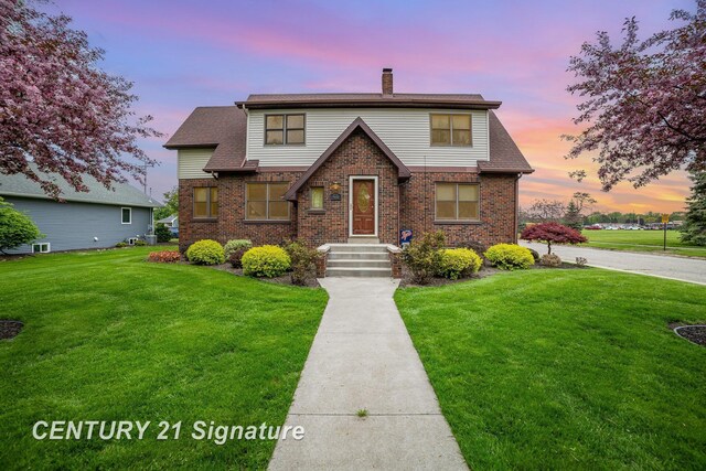 9610 Saginaw St, Reese, MI 48757 - view of front of house with a chimney, a yard, and brick siding