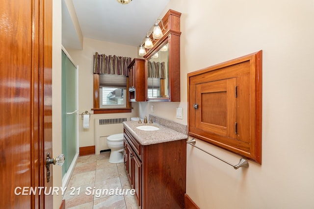 9610 Saginaw St, Reese, MI 48757 - bathroom featuring radiator heating unit, toilet, vanity, a shower with shower door, and baseboards