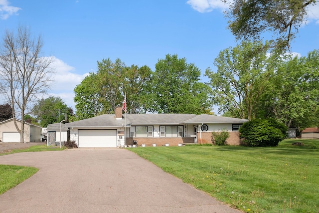 ranch-style house featuring driveway, a front lawn, a chimney, an attached garage, and brick siding