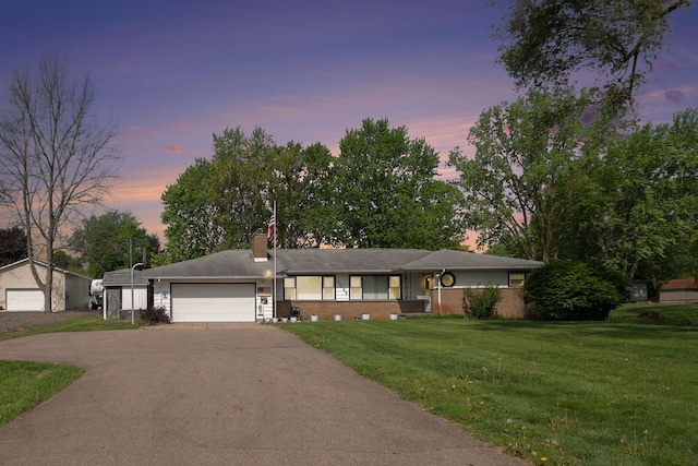 ranch-style house with asphalt driveway, a front lawn, a chimney, and an attached garage