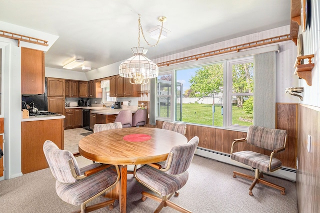 dining room with light colored carpet, a chandelier, a baseboard heating unit, and wood walls