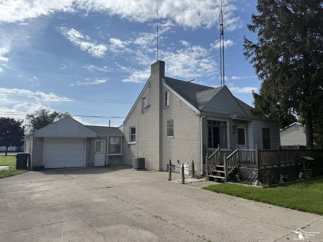 4971 Elm St, Newport, MI 48166 - view of front facade featuring cooling unit, concrete driveway, brick siding, an attached garage, and a chimney