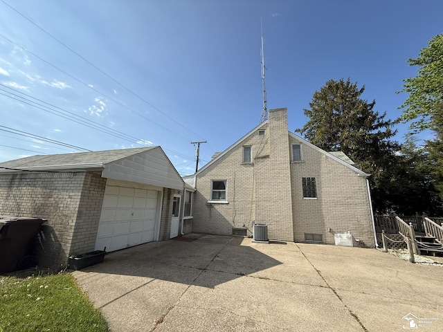 4971 Elm St, Newport, MI 48166 - view of side of property with central AC, brick siding, driveway, a detached garage, and an outdoor structure