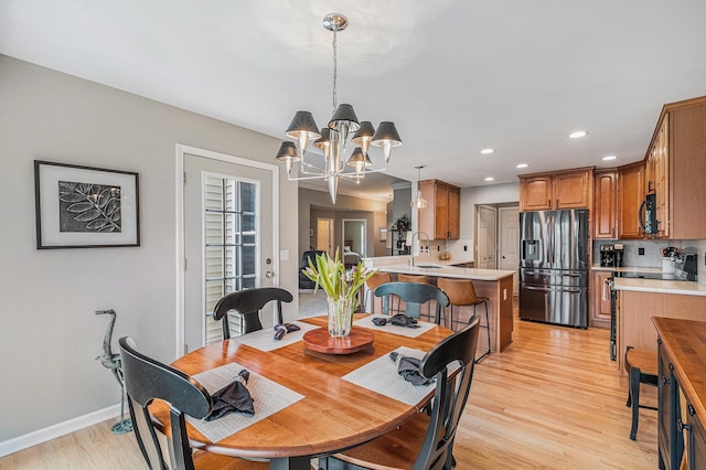 5489 Hidden Oak Cir, Linden, MI 48451 - dining area with a chandelier, recessed lighting, light wood-type flooring, and baseboards