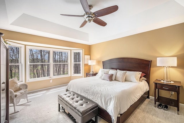5489 Hidden Oak Cir, Linden, MI 48451 - carpeted bedroom with a tray ceiling, baseboards, and ceiling fan