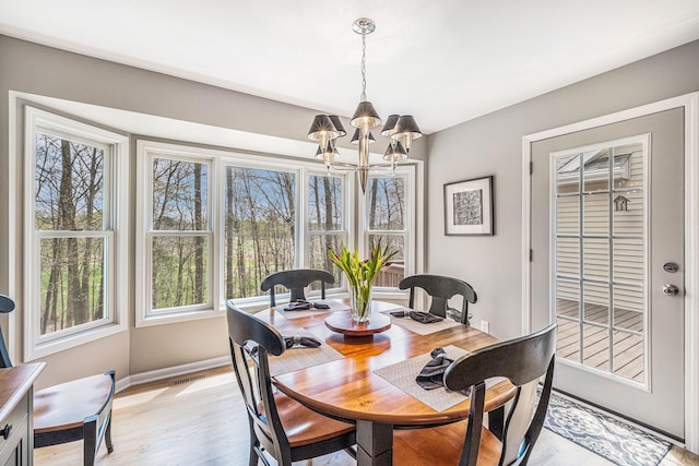5489 Hidden Oak Cir, Linden, MI 48451 - dining space with a chandelier, light wood-style flooring, and baseboards