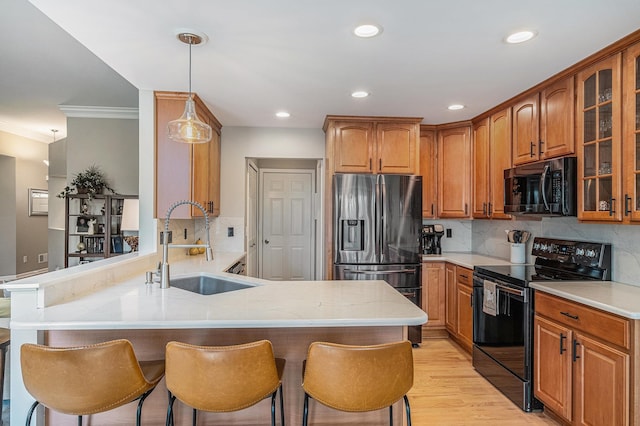 5489 Hidden Oak Cir, Linden, MI 48451 - kitchen with electric range, stainless steel refrigerator with ice dispenser, a peninsula, a sink, and ornamental molding