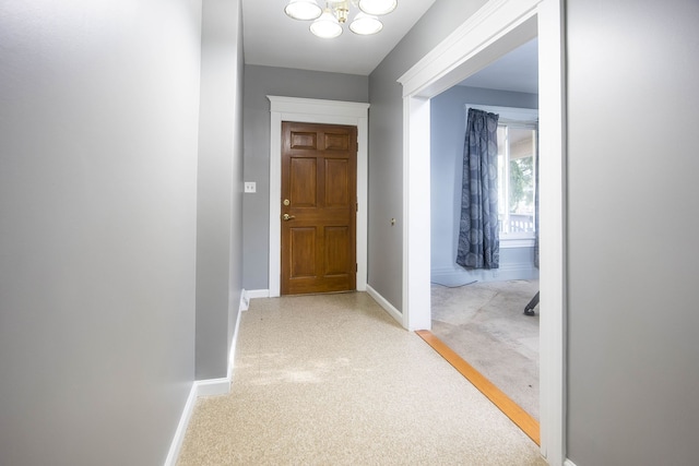 1309 Division St, Port Huron, MI 48060 - corridor with baseboards, light carpet, and a chandelier