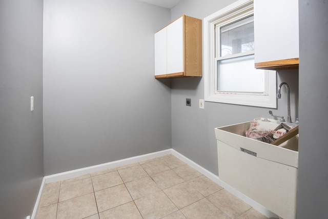 1309 Division St, Port Huron, MI 48060 - washroom featuring electric dryer hookup, cabinet space, baseboards, and light tile patterned floors