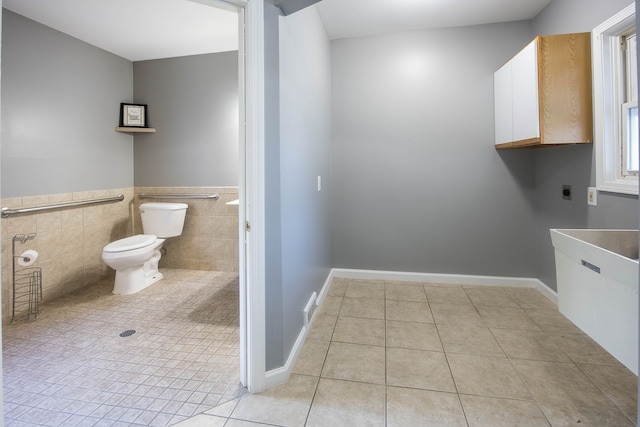 1309 Division St, Port Huron, MI 48060 - laundry area featuring light tile patterned flooring, hookup for an electric dryer, tile walls, and cabinet space