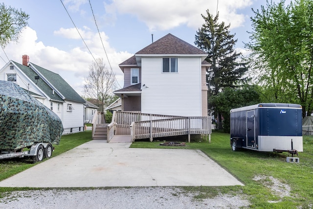 1309 Division St, Port Huron, MI 48060 - rear view of house with a wooden deck, a yard, and roof with shingles