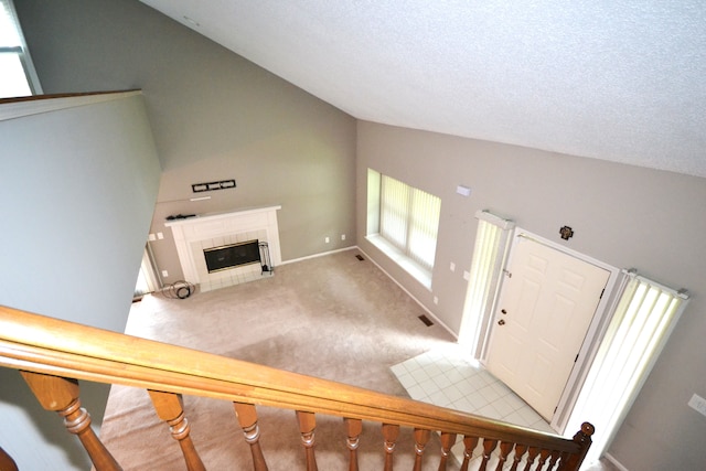 2 Cornell Ct, Dearborn, MI 48124 - entryway with lofted ceiling, light carpet, a tile fireplace, a textured ceiling, and baseboards