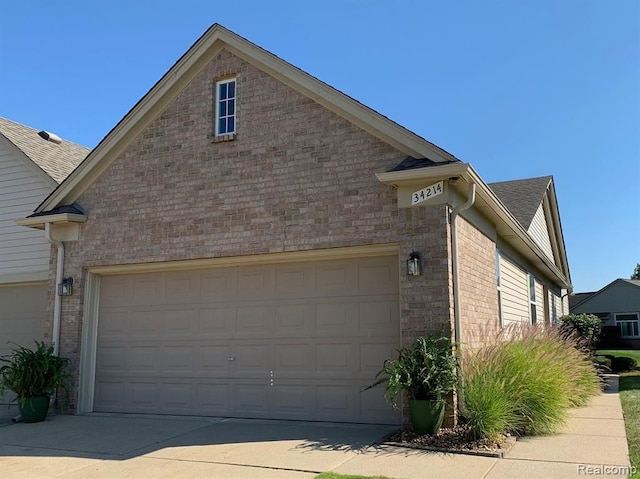 34214 Birchway Cir, Sterling Heights, MI 48312 - view of home's exterior featuring driveway, brick siding, and a garage