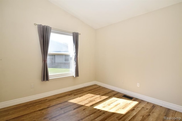 34214 Birchway Cir, Sterling Heights, MI 48312 - empty room with vaulted ceiling, wood finished floors, and baseboards