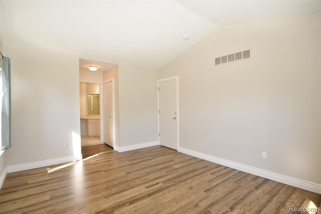 34214 Birchway Cir, Sterling Heights, MI 48312 - spare room featuring wood finished floors, baseboards, and vaulted ceiling