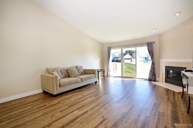 34214 Birchway Cir, Sterling Heights, MI 48312 - living room with a tiled fireplace, wood finished floors, lofted ceiling, baseboards, and recessed lighting