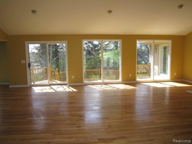 6850 Arlington, West Bloomfield, MI 48322 - unfurnished living room featuring baseboards, wood finished floors, and vaulted ceiling