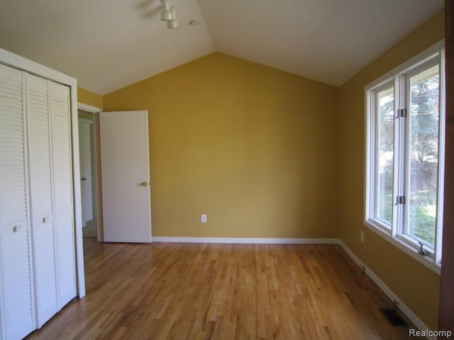 6850 Arlington, West Bloomfield, MI 48322 - unfurnished bedroom featuring lofted ceiling, light wood finished floors, a closet, and baseboards