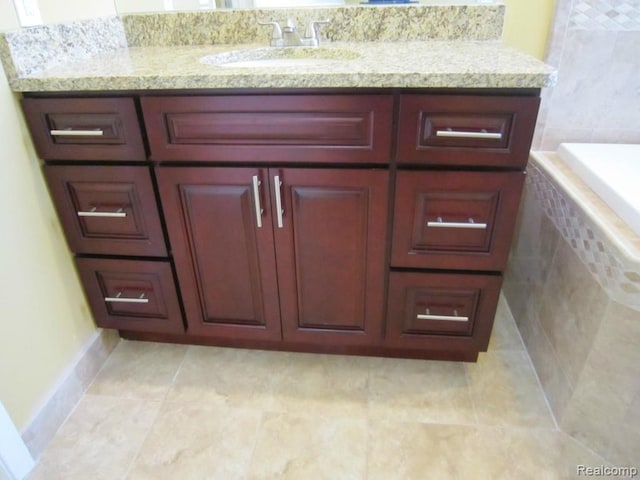 6850 Arlington, West Bloomfield, MI 48322 - bathroom with vanity, tiled bath, baseboards, and tile patterned flooring