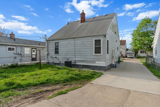 7044 Continental Ave, Warren, MI 48091 - rear view of house with a chimney, fence, cooling unit, and roof with shingles