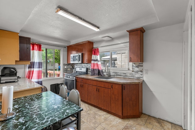 7044 Continental Ave, Warren, MI 48091 - kitchen with a sink, stainless steel appliances, decorative backsplash, a textured ceiling, and light countertops