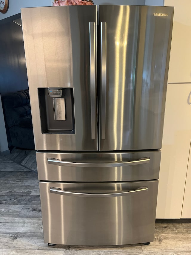 detailed view of stainless steel fridge and wood finished floors