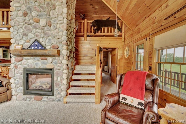 10071 Hillman Rd, Lakeview, MI 48850 - living area with carpet floors, wooden walls, vaulted ceiling, a stone fireplace, and wood ceiling