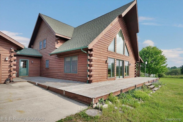 10071 Hillman Rd, Lakeview, MI 48850 - view of side of home with a deck, log exterior, a shingled roof, and a yard