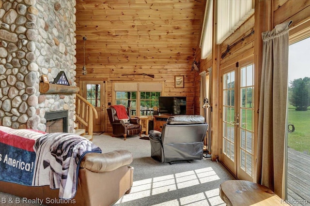 10071 Hillman Rd, Lakeview, MI 48850 - carpeted living area with french doors, plenty of natural light, a fireplace, wooden walls, and a towering ceiling