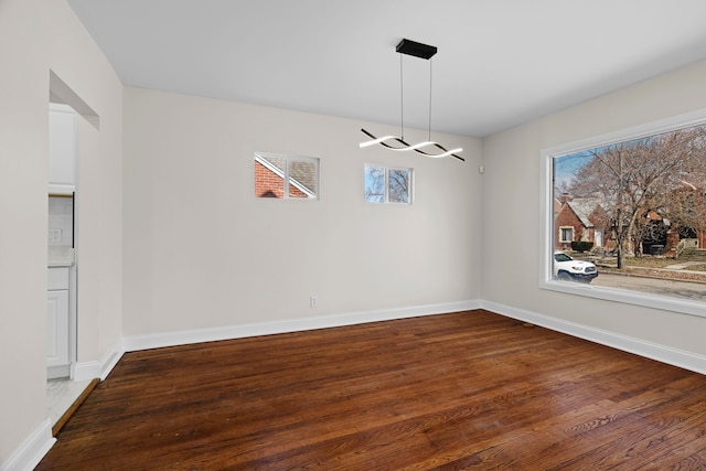 5027 Audubon Rd, Detroit, MI 48224 - spare room featuring a chandelier, wood finished floors, baseboards, and plenty of natural light