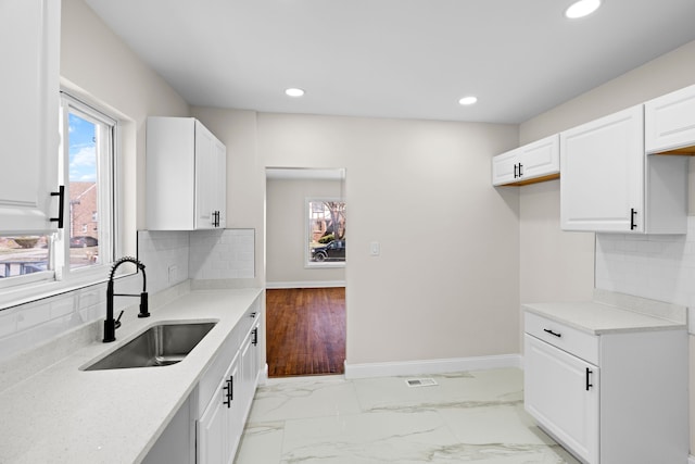 5027 Audubon Rd, Detroit, MI 48224 - kitchen featuring a sink, recessed lighting, light countertops, decorative backsplash, and white cabinetry