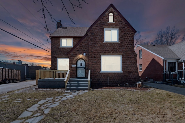 5027 Audubon Rd, Detroit, MI 48224 - tudor house featuring brick siding, a chimney, and a front yard