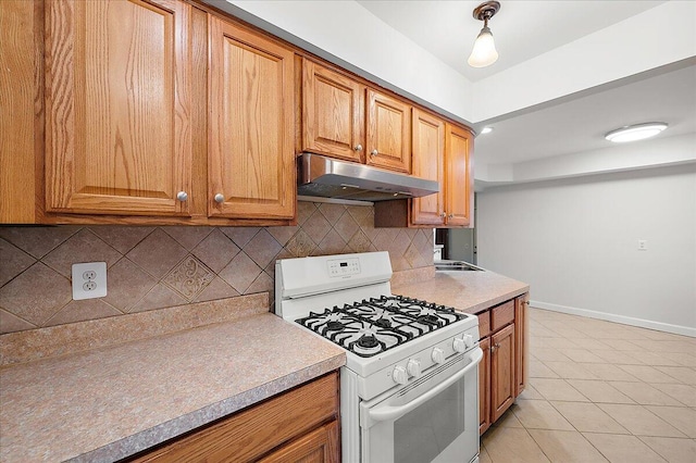 30657 Moulin Ave, Warren, MI 48088 - kitchen featuring gas range gas stove, under cabinet range hood, light tile patterned flooring, and tasteful backsplash