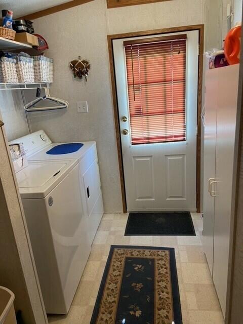 laundry area with washing machine and dryer and light flooring