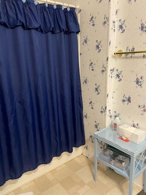 full bath featuring wallpapered walls, tile patterned floors, and curtained shower
