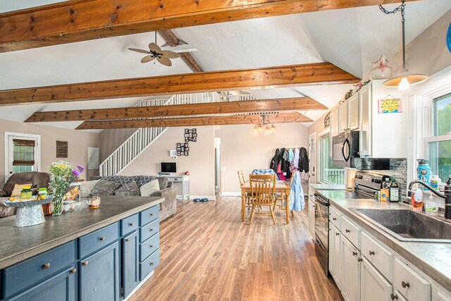 557 W James St, Lawrence, MI 49064 - kitchen featuring stainless steel electric stove, open floor plan, blue cabinets, a sink, and white cabinets
