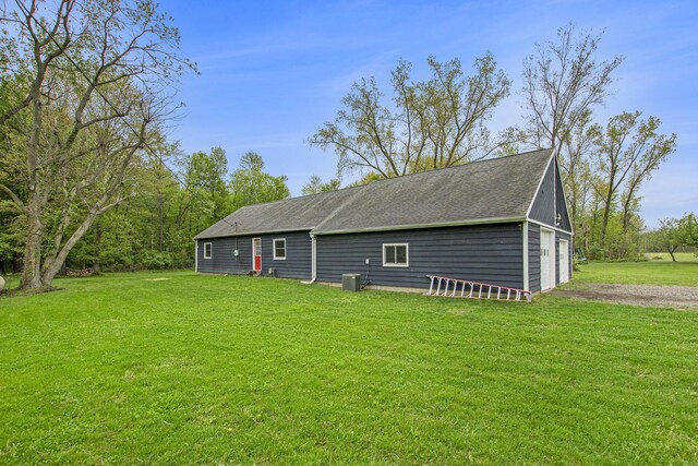 557 W James St, Lawrence, MI 49064 - rear view of house featuring a lawn, a shingled roof, and cooling unit