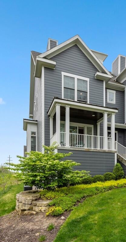 631 Greenslate Dr SE, Ada, MI 49301 - view of front facade with a chimney and a balcony