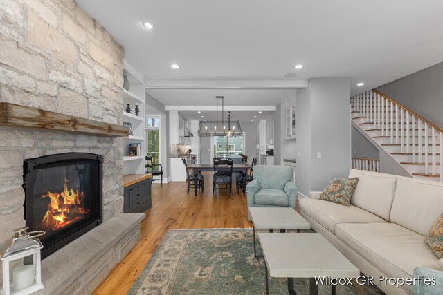 631 Greenslate Dr SE, Ada, MI 49301 - living area with light wood finished floors, a stone fireplace, recessed lighting, and stairway
