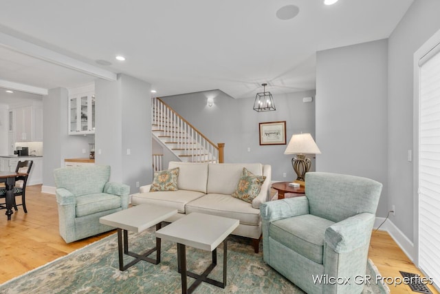 631 Greenslate Dr SE, Ada, MI 49301 - living area with light wood-style floors, recessed lighting, stairs, a chandelier, and baseboards