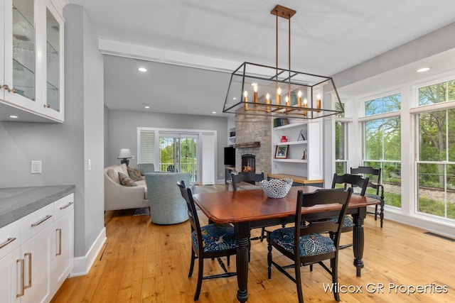 631 Greenslate Dr SE, Ada, MI 49301 - dining area with healthy amount of natural light, light wood finished floors, a fireplace, and recessed lighting