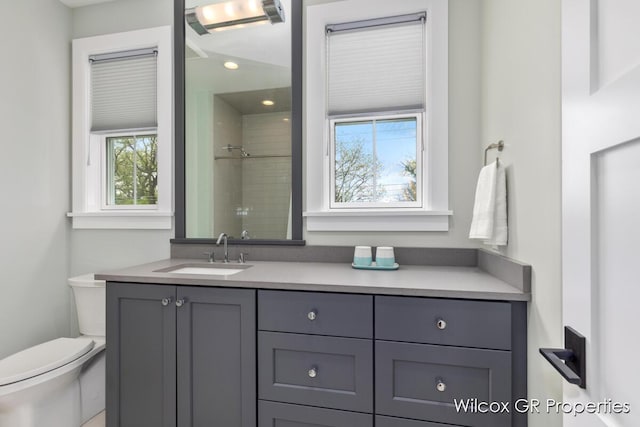 631 Greenslate Dr SE, Ada, MI 49301 - bathroom featuring a tile shower, toilet, vanity, and recessed lighting