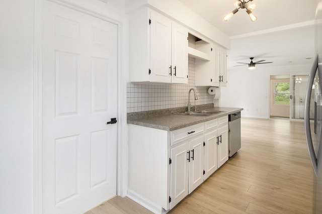 kitchen with a sink, stainless steel appliances, tasteful backsplash, white cabinets, and a ceiling fan