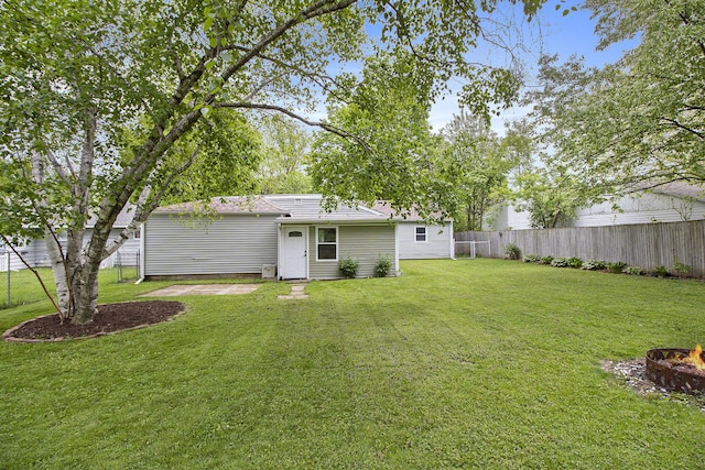 rear view of property with a fire pit