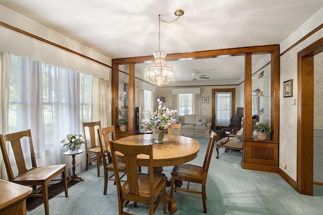dining space with light colored carpet, a chandelier, ceiling fan, and wallpapered walls