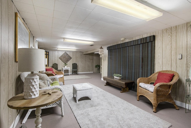 carpeted living area featuring wood walls